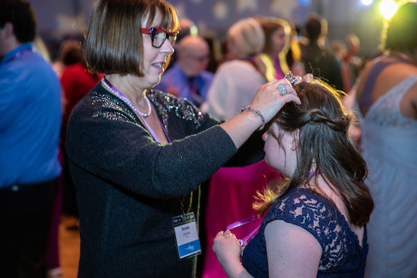 A woman and man posing in a silly way in the photo booth